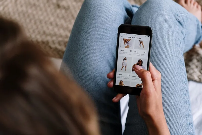 Shopper scrolling a clothing product list on a smartphone