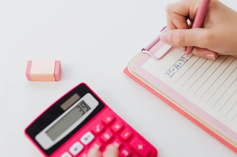 Close-up of hands using a calculator to work out A/B test sample size math