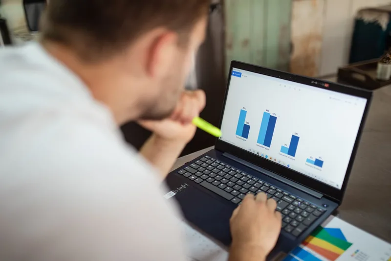 Marketing analyst reviewing ad spend and performance data on a laptop screen