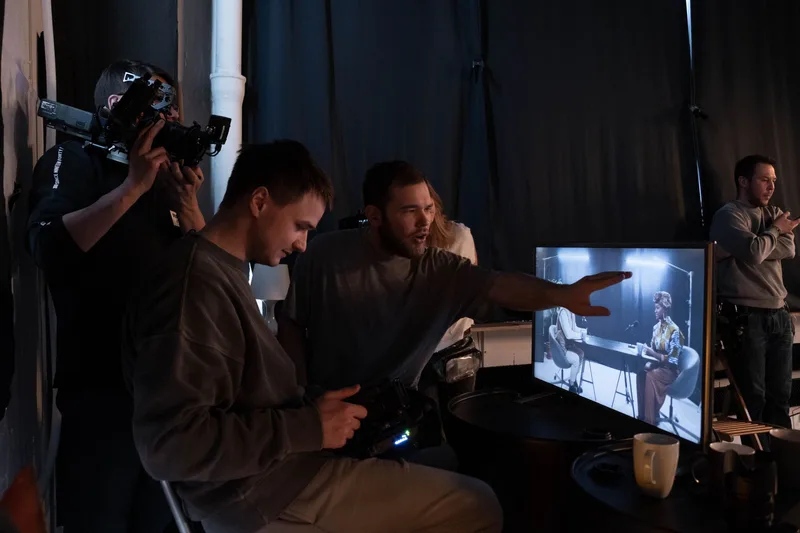 Video production crew reviewing footage on a monitor during an ad creative shoot