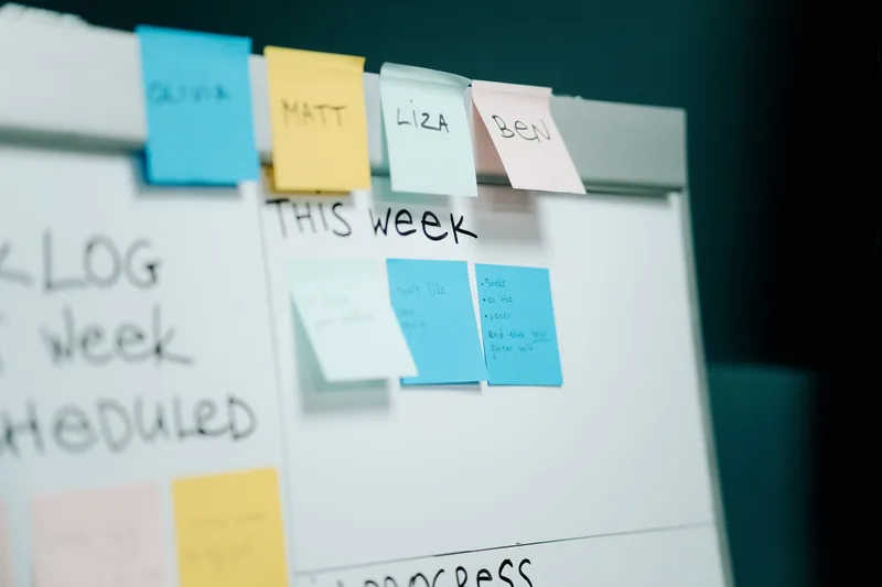 Whiteboard with sticky notes sorted into backlog, this week and in progress columns