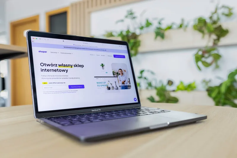 Close-up of a laptop displaying an open ecommerce website in a modern office