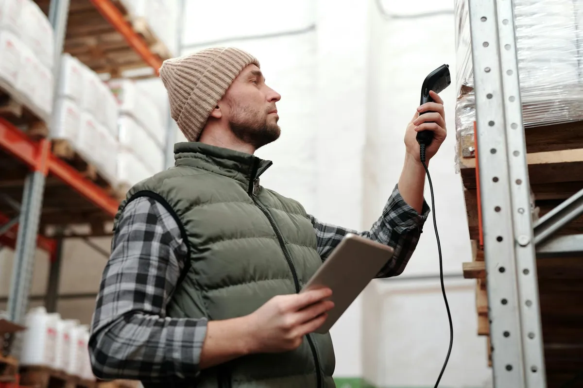 Ecommerce warehouse worker scanning shipping labels on parcels ready for dispatch