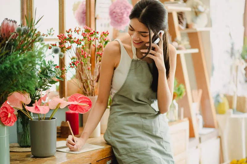 small business owner on a phone call while working in her shop